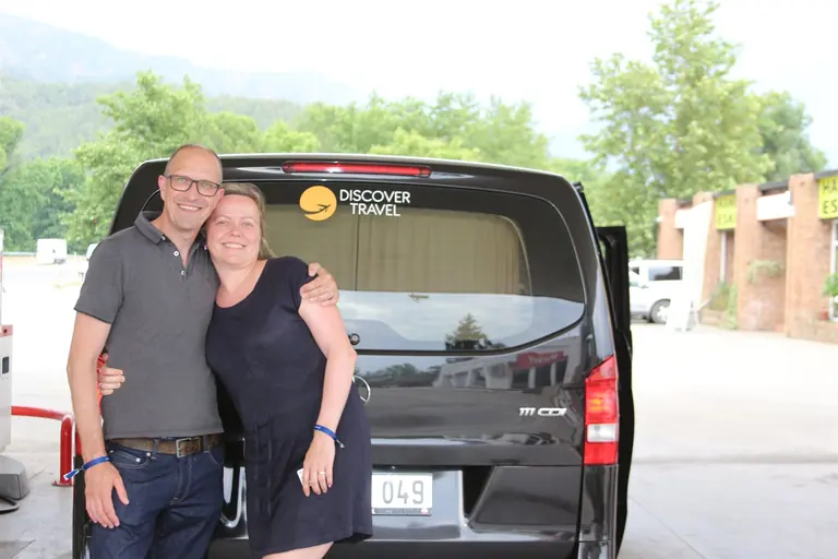 Gasten van Discover Travel naast een luxe Mercedes Sprinter met logo