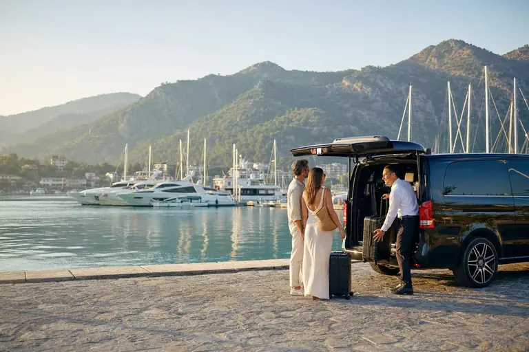 Discover Travel guests beside the private luxury airport transfer vehicle